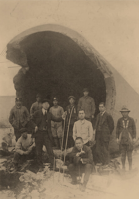 Staff members in front of a collapsed chimney
